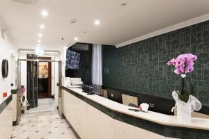 a salon with a counter with pink flowers on the wall at Glam Luxury Rome in Rome
