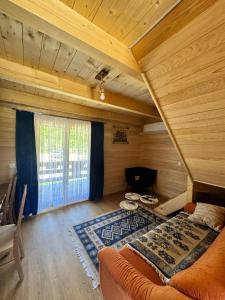 ein Dachzimmer mit einem Sofa und einem Fenster in der Unterkunft Bungalow Fly Fishing Kljuc River Sanica in Zolaći