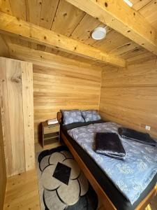 Cette chambre comprend un lit dans une cabane en bois. dans l'établissement Bungalow Fly Fishing Kljuc River Sanica, à Zolaći