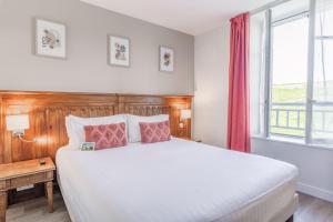 ein Schlafzimmer mit einem großen Bett und einem Fenster in der Unterkunft Hotel Restaurant Spa du Tumulus Carnac in Carnac