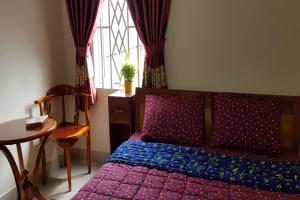 a bedroom with a bed and a table and a window at Mifa Homestay in Hương Trà