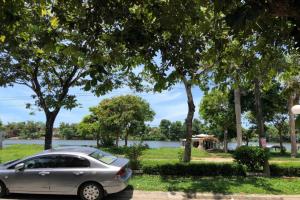a silver car parked in front of a lake at Mifa Homestay in Hương Trà
