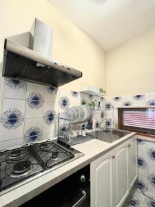 Il dispose d'une cuisine avec un four et du carrelage bleu et blanc. dans l'établissement Casa Vacanze Villa Angelina, à Giardini Naxos