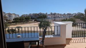 balcón con mesa azul y vistas a la ciudad en La Torre Golf Resort, en Torre-Pacheco