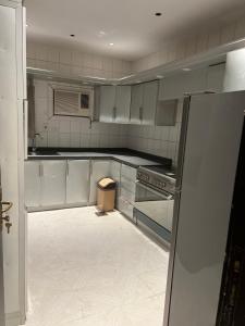 a kitchen with white cabinets and a stove top oven at شقة3 غرف نوم في حي الروضة in Jeddah