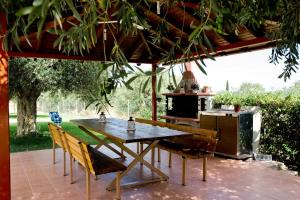a wooden table and chairs on a patio with a stove at Agrelia studios in Agios Nikolaos