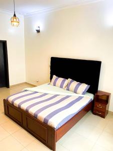 Schlafzimmer mit einem großen Bett mit einem schwarzen Kopfteil in der Unterkunft COMFORT B&B in Kigali