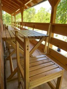 un tavolo da picnic in legno e una panca in una cabina di Camping Oaza a Bela Crkva