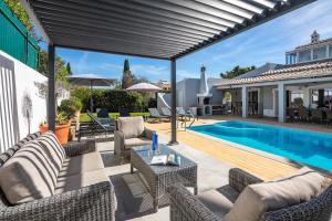 un patio al aire libre con sillas y una piscina en Villa at walking distance from center and beach!, en Carvoeiro