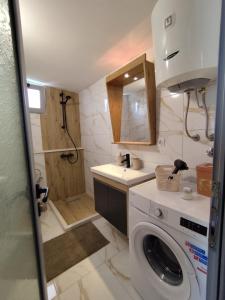 a bathroom with a washing machine and a shower at Apartment Sorelle in Utjeha