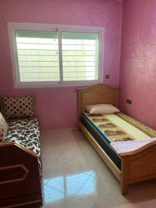 a small bedroom with a bed and a window at Appartement a loué fes in Fès
