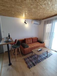 uma sala de estar com um sofá e uma mesa em Apartment Sorelle em Utjeha