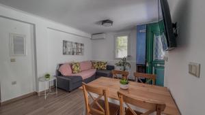 ein Wohnzimmer mit einem Tisch und einem Sofa in der Unterkunft Spyros Stone Apartment in Lazaráta