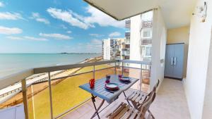 a balcony with a table and chairs and the ocean at Panoramic View face Mer in Saint-Gilles-Croix-de-Vie