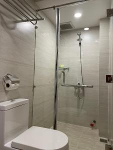 a bathroom with a glass shower with a toilet at Mia Hotel in Ho Chi Minh City