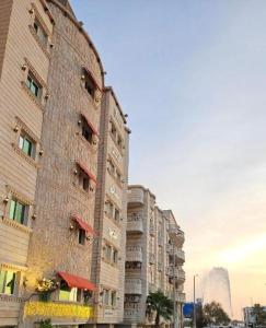 duży budynek z cegły obok niektórych wysokich budynków w obiekcie رحال البحر للشقق المخدومة Rahhal AlBahr Serviced Apartments w mieście Dżudda