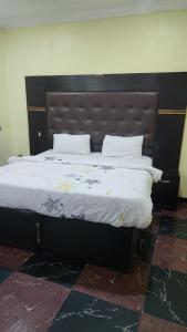 a large bed with a black headboard in a room at Paviosca Hotel in Umuahia