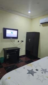 a bedroom with a bed and a flat screen tv at Paviosca Hotel in Umuahia