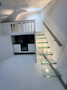 a staircase in a white room with a kitchen at Nice flat near Church Street in London