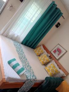 a bed in a room with a window and pillows at Cosmic Haven Studio in Mombasa