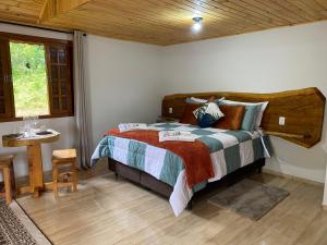 a bedroom with a large bed with a wooden headboard at Chalé Recanto Belo. in São Mateus