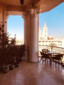 a balcony with a table and chairs and a building at Alam B&B Luxor in Luxor