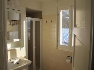 a bathroom with a sink and a shower and a window at Oltrella Country House in Ponte Nizza