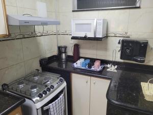 a kitchen with a stove and a microwave at SuhcasaCopacabana 54 Wonderful in Rio de Janeiro