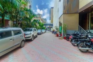 una calle con coches y motocicletas estacionados en la acera en Hotel V'ertu en Nueva Delhi