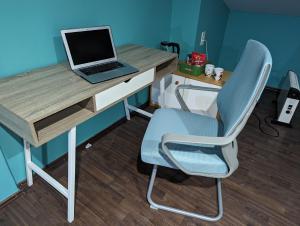 einen Schreibtisch mit einem Laptop und einem Stuhl in einem Zimmer in der Unterkunft Dragon's Lair in Celje