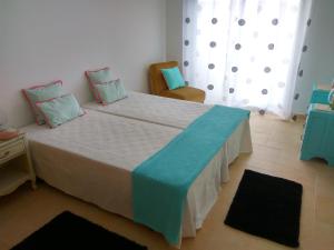 um quarto com uma cama grande e um cobertor azul em Casa dos Medros em São Martinho do Porto