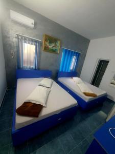 2 letti in una camera con pareti e finestre blu di Vila Oaza a Mangalia