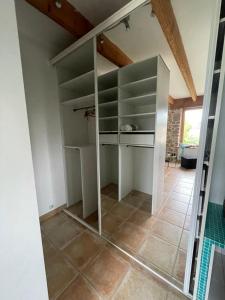a walk in closet with glass shelves in a room at chambre St Malo Cancale in Saint-Méloir-des-Ondes +3 photos
