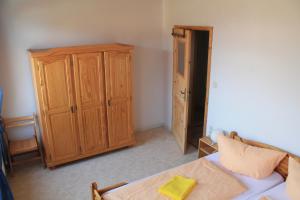 - une chambre avec une armoire en bois et un lit dans l'établissement Ferienhof Rügen, à Maltzien