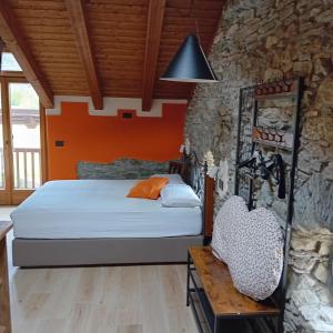 a bedroom with a bed and a stone wall at Le Foyer de Grand-mère in Fenis