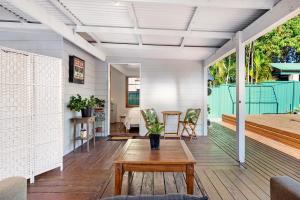 a living room with a wooden table on a porch at The Mellow Haven in Gold Coast