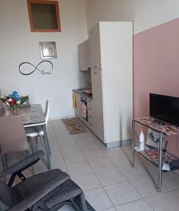 a kitchen with a refrigerator and a table and a dining room at Casa Tabor in Ariano Irpino