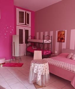 a pink bedroom with two beds and a table at Casa Tabor in Ariano Irpino