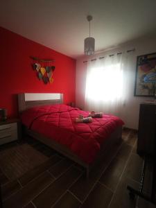 - une chambre avec des murs rouges et un lit avec une couette rouge dans l'établissement Casa la Grenadine, à Esmoriz