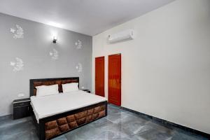 um quarto com uma cama e uma porta vermelha em OYO Conifer INN em Meerut