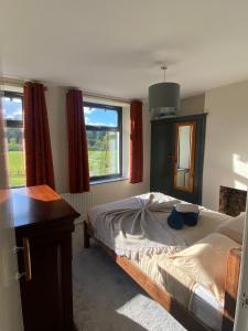 um quarto com uma cama e duas janelas em Castle Cottage em Kendal