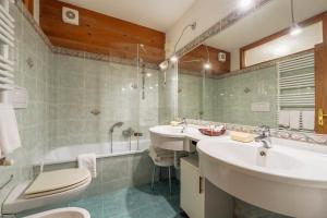 bagno con vasca, lavandino e servizi igienici di Barisetti Sport Hotel a Cortina dʼAmpezzo