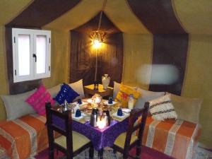 メルズーガにあるMerzouga Luxury Desert camp, excursion and activitiesのダイニングルーム(テーブル、ソファ付)