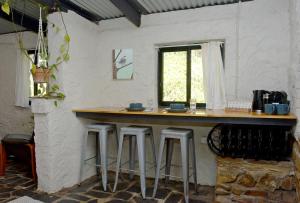 een bar in een witte kamer met krukken bij The Studio at Meadowbrook in Kersbrook