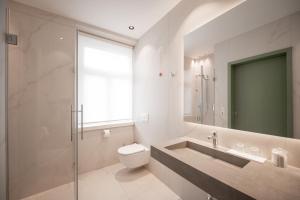 a bathroom with a toilet and a sink and a mirror at Hotel Europa Splendid in Merano