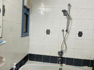 een badkamer met een douche en een bad bij Relaxation Quiet Room Apartment in Abu Dhabi