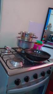 a stove with pots and pans on top of it at Cosmic Haven Studio in Mombasa