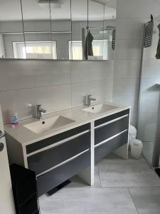 a bathroom with two sinks and a mirror at Ferienwohnung, Thüringen 