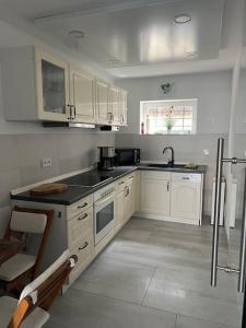 a kitchen with white cabinets and a black counter top at Ferienwohnung, Thüringen 