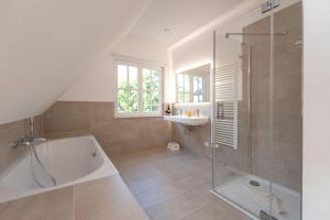 a bathroom with a tub and a sink and a shower at Ferienhaus Nordstern in Zirchow +28 photos